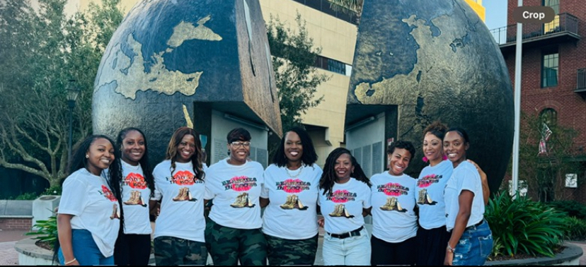 Members posing in front of the Savannah globe monument in their club tees