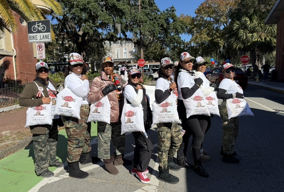 Members lined up with Beauties in Boots tote bags before the parade