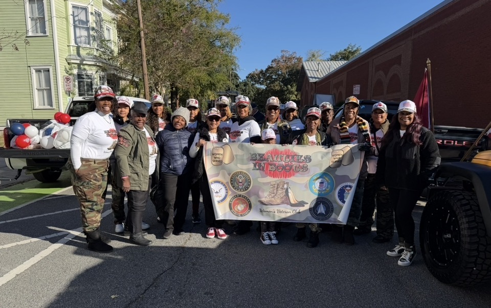 Members holding the Beauties in Boots Women's Veteran Club banner at the parade