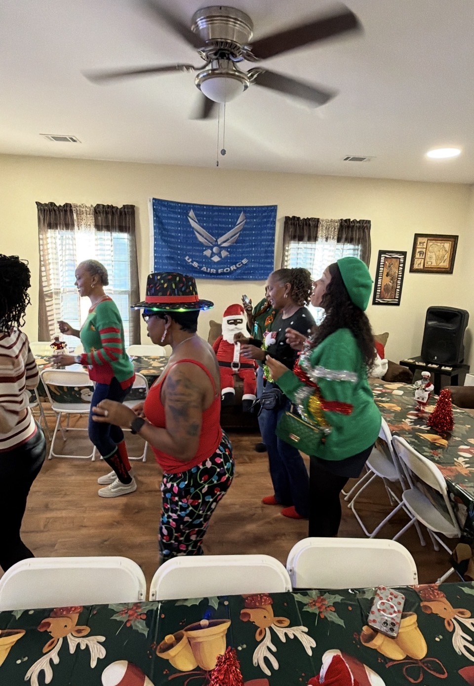 Members dancing in festive holiday attire at the Christmas party
