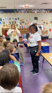Member reading to children during a school community visit