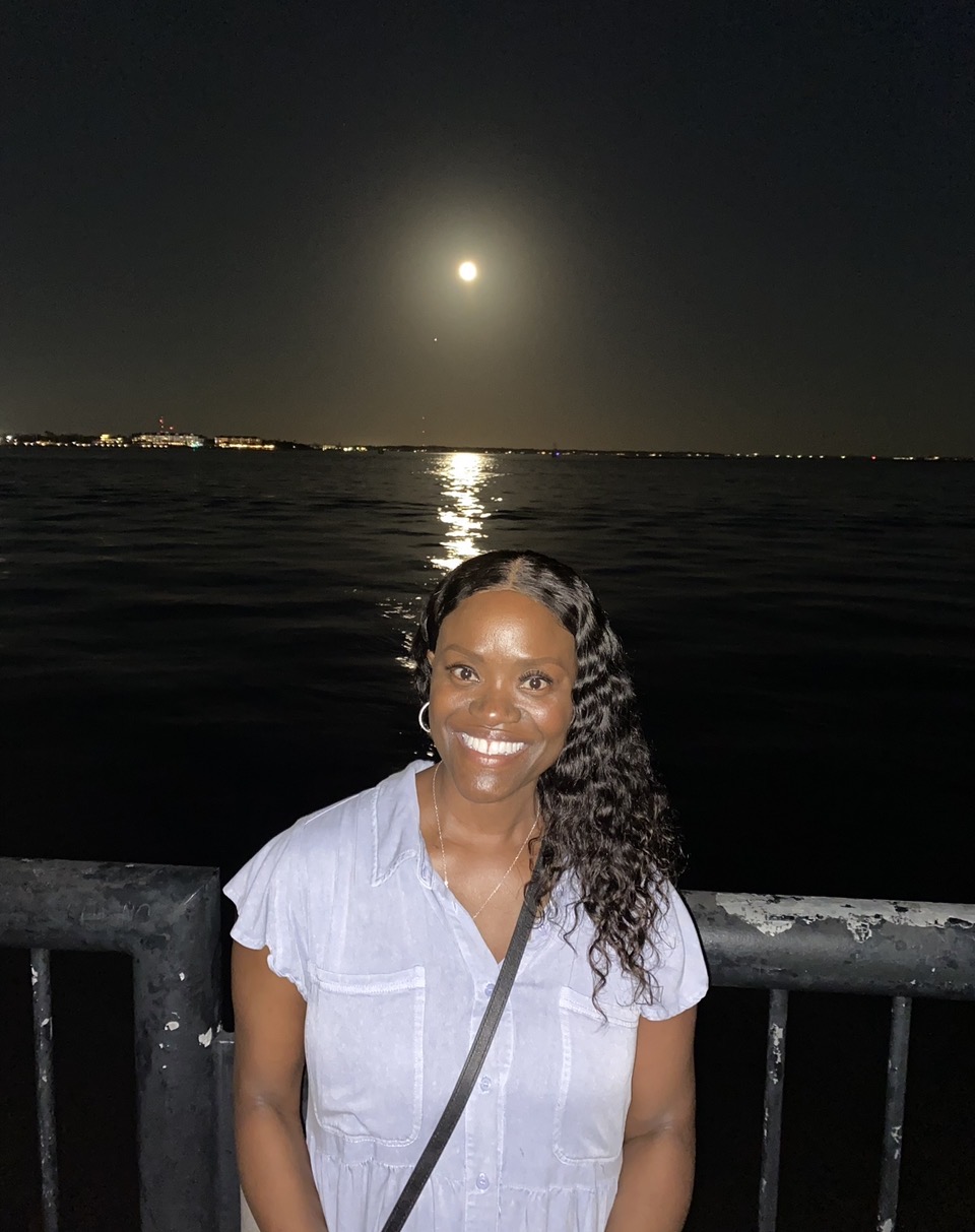 Captain Nathacha Rock by the water under a full moon